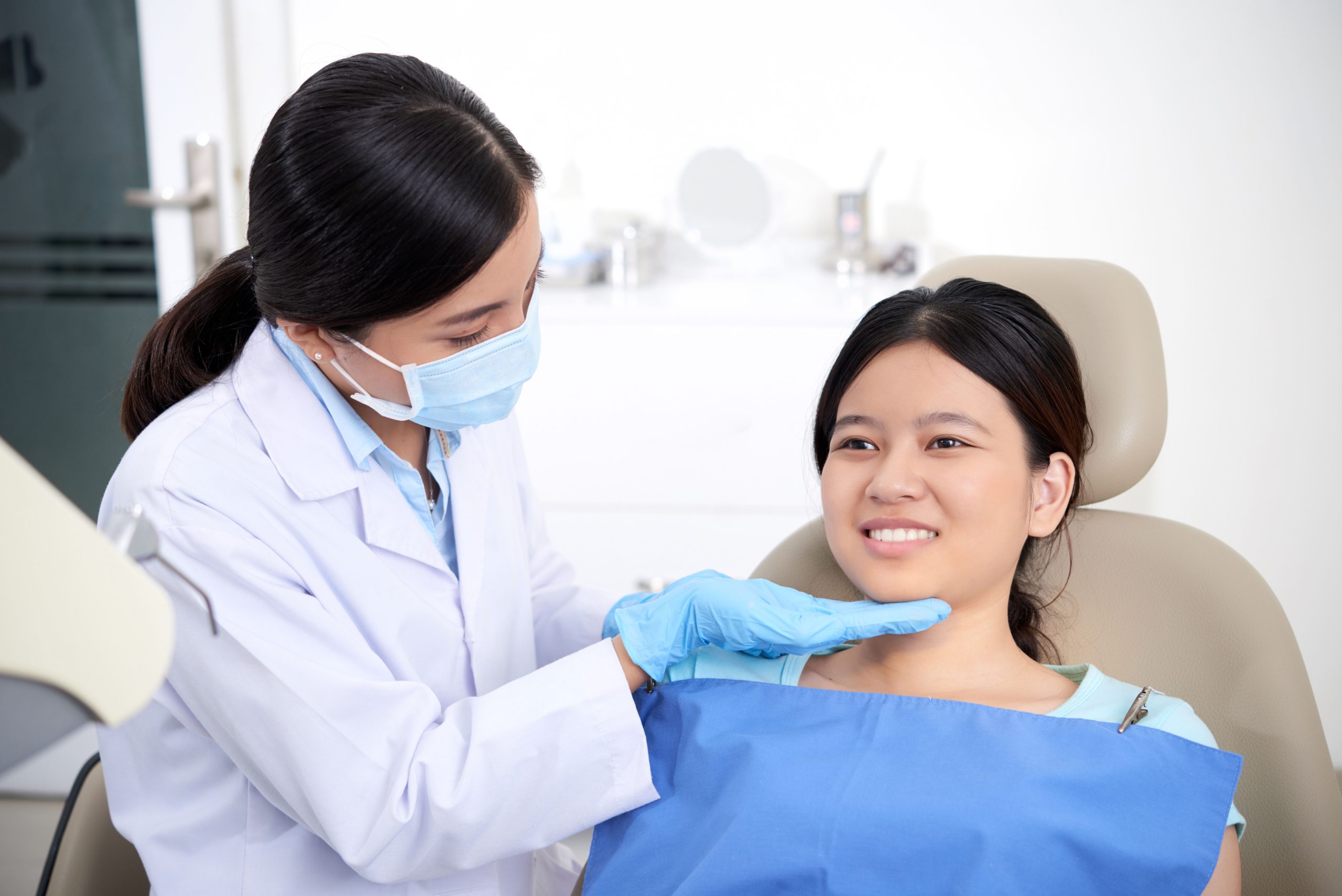 asian-female-dentist-checking-out-patient-s-teeth-woman-smiling (1) (1)